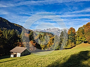 hiking in the beautiful Weisstannen valley. Fall colors in the woods. Alp hut with a view of the mountains