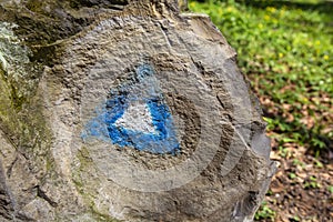 Hiking blue triangle paint marking on a rock
