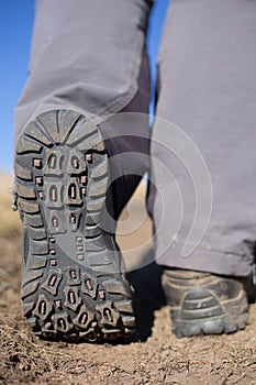 Hiking boot closeup on mountain rocks.