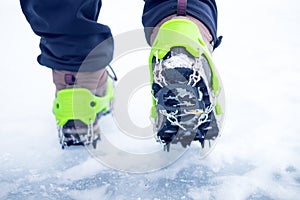 Hiking boots with equipment for ice. Snow like a background and sun. Sun is shining. Moutains and travel.