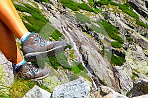 Hiking boots on leg of hiker in mountains