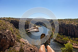 Hiking boots and legs above river and canyon. Woman hiking at Katherine gorge. Aerial view. Katherine gorge, Nitmiluk national
