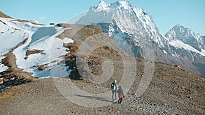 Hiking with child in mountains with snowy peaks. Creative. Mother and boy climb mountains on autumn sunny day. Family