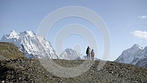 Hiking with child in mountains with snowy peaks. Creative. Mother and boy climb mountains on autumn sunny day. Family