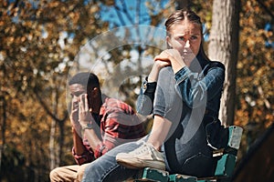 Hiking, conflict and couple argue in a forest, annoyed and sad while sitting, lost and unhappy. Sad, woman and man