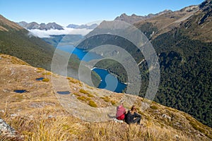 Hiking couple admiring scenic view of lakes Fergus, Lake Gunn and Livingstone mountain range