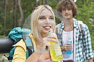 Hiking couple with energy drinks in forest