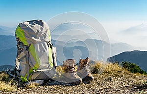 Hiking equipment. Backpack and boots on top of mountain.