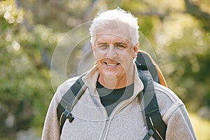 Hiking, fitness and elderly man in nature for exercise and trekking in the park, vitality and active lifestyle portrait