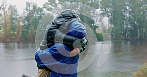 Hiking, freedom and an interracial couple hugging in the rain outdoor in nature together for romantic adventure. Smile