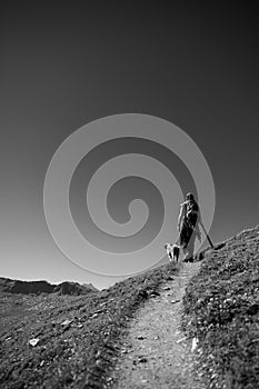 Hiking with friendly dog on the alps