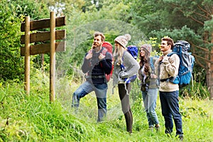 Hiking friends with backpacks at signpost