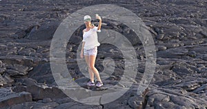 Hiking Girl taking picture with flowing lava in Kilauea volcano Hawaii
