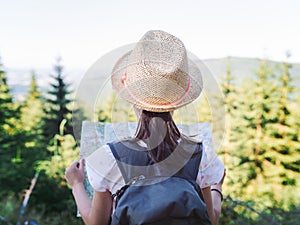 Hiking girl traveler with backpack checks map