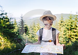 Hiking girl traveler with backpack checks map