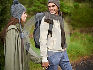 Hiking hand in hand. a young couple hiking hand in hand in the great outdoors.