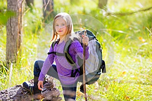 Hiking kid girl with backpack in autum poplar forest