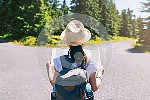 Hiking little girl traveler at the crossroads with backpack