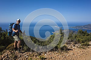 Hiking Lycian way. Man tourist is standing on path over Mediterranean sea coast on Lycian Way trail