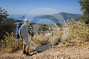 Hiking Lycian way. Man tourist is standing on path over Mediterranean sea coast on Lycian Way trail above Kalkan, Trekking