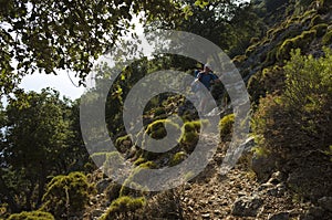 Hiking Lycian way. Man is trekking on steep slope stony path, on mountain on Mediterranean coast, evening warm light