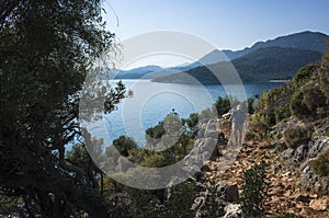 Hiking Lycian way. Man is trekking on stony path along Mediterranean sea coast on Lycian Way trail from Ucagiz to Demre