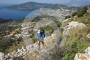 Hiking Lycian way. Man is trekking on stony path high above Mediterranean sea coast on Lycian Way trail near Kalkan