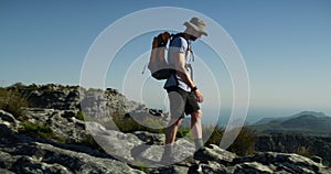 Hiking, man and adventure or journey to mountain top, nature and travel in hills with backpack. Person, trekking and