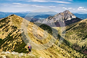 Hiking man with baby carrier backpack. Beautiful mountain landscape