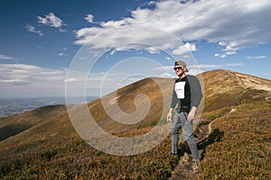 Hiking man, climber or trail runner in mountains, inspirational landscape. Motivated hiker looking at mountain view.