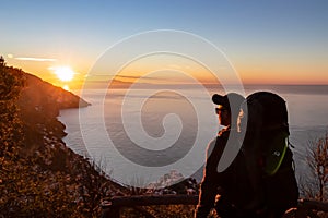 Hiking man enjoying scenic sunrise from the Path of the Gods between Positano and Praiano on the Amalfi Coast, Campania, Italy