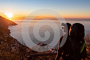 Hiking man enjoying scenic sunrise from the Path of the Gods between Positano and Praiano on the Amalfi Coast, Campania, Italy