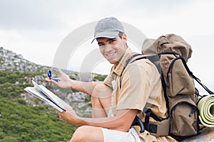 Hiking man with map on mountain terrain photo