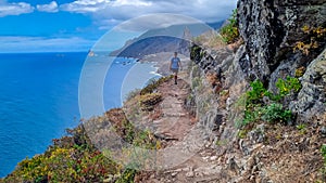 Hiking man with scenic view of coastline of Anaga mountain range on Tenerife, Canary Islands, Spain. View on Cabezo el Tablero photo