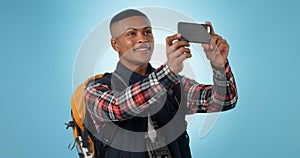 Hiking, man and smartphone with social media, photograph and travel on a studio background. Person, traveller and model