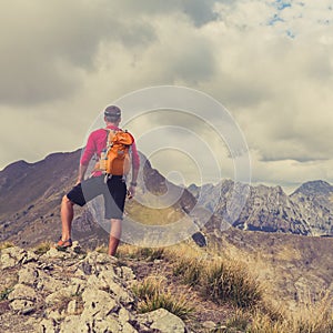 Hiking man or trail runner in mountains