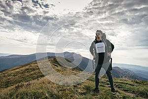 Hiking man or trail runner in mountains, inspirational landscape. Motivated hiker with backpack looking at mountain view