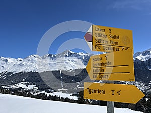 Hiking markings and orientation signs with signposts for navigating in the idyllic winter ambience of the Swiss Alps