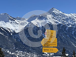 Hiking markings and orientation signs with signposts for navigating in the idyllic winter ambience of the Swiss Alps