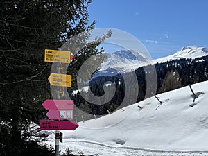 Hiking markings and orientation signs with signposts for navigating in the idyllic winter ambience of the Swiss Alps