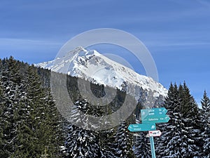 Hiking markings and orientation signs with signposts for navigating in the idyllic winter ambience of the Swiss Alps