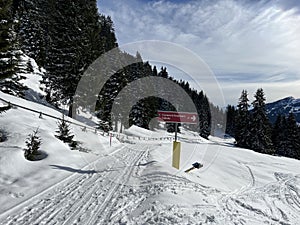Hiking markings and orientation signs with signposts for navigating in the idyllic winter ambience of the Swiss Alps