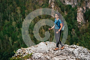 Hiking in the mountains. The concept of active recreation. Traveling woman with a backpack on the background of mountains.