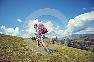 Hiking in the mountains in the summer with a backpack.