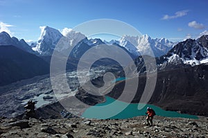 Hiking in Nepal Himalayas, Male tourist walking up to Gokyo Ri with view of Gokyo lake, Gokyo village, Ngozumba glacier