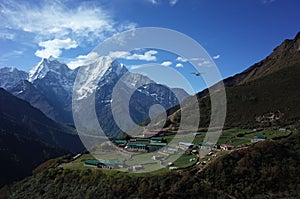 Hiking in Nepal Himalayas, Small airplane flying over Dhole village 4200 m, Thamserku mountain on background