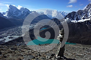 Hiking in Nepal Himalayas, Stone pyramid on Gorio Ri with view of Gokyo lake, Gokyo village, Ngozumba glacier and mountains