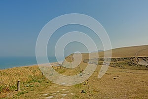 Hiking path along a field and rocky cliffs on the French Northe sea coast,