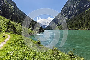 Hiking path around mountain lake. Alps mountains, Stillup Lake, Austria, Tyrol Region