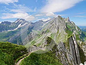 Hiking path leading through Alpstein massif with Altmann and Saentis in the background. Appenzell, Switzerland.